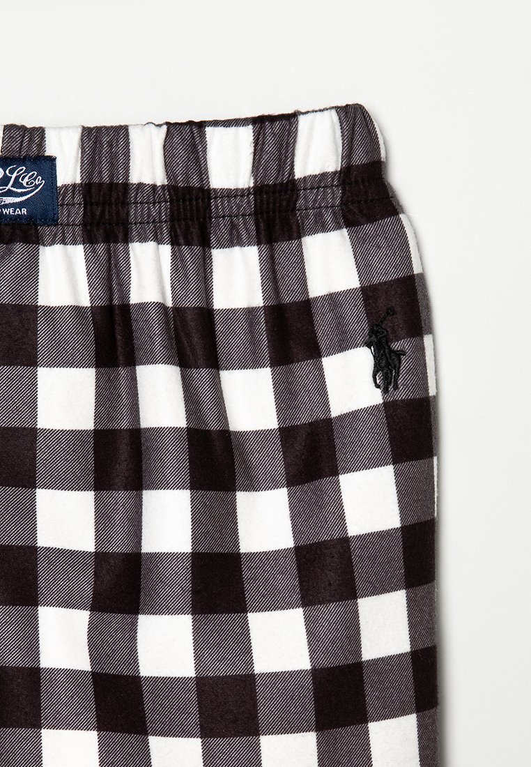 Shorts à carreaux noir et blanc avec une taille élastique. Présente un petit logo brodé, un tissu doux et un design décontracté.