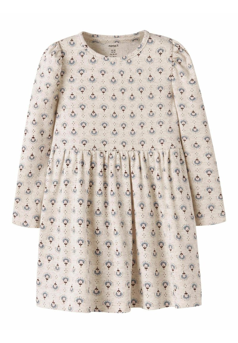 Vestido de manga larga en tela de color beige claro, con un delicado patrón floral en azul y marrón, con cintura fruncida y textura suave.