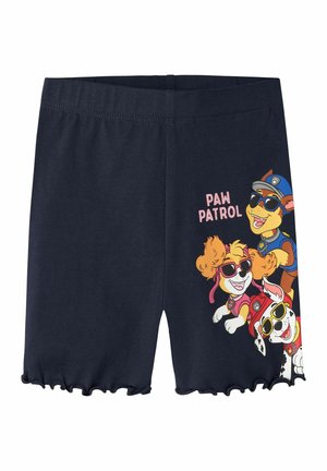 Niebieskie dziecięce szorty z falbankowymi brzegami, z kolorowymi postaciami z Psiego Patrolu w okularach przeciwsłonecznych oraz napisem „PAW PATROL” na prawej nogawce.