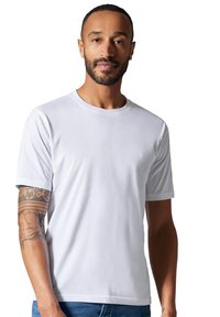 Hvid kortærmet t-shirt med rund halsudskæring og en glat tekstur, båret af en person med en synlig tatovering på venstre arm.