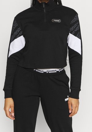 Felpa cropped nera con colletto zip, caratterizzata da accenti bianchi e pannelli neri testurizzati sulle maniche. Logo PUMA in evidenza.
