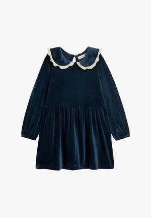 Laivastonsininen samettinen mekko, jossa on pitkät hihat, röyhelökaulus ja kerrostettu vyötärö. Selässä on avonainen silmäkuvio.