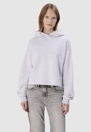 Hellgrauer, verkürzter Hoodie mit Kapuze, gerippten Bündchen und weichem Material, kombiniert mit verwaschenen grauen Jeans und einem dekorativen, mit Nieten versehenen Gürtel.