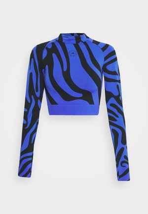 Pitkähiha, vartalonmyötäinen crop-top korkealla kauluksella, sinivalkoisilla seepra-raidoilla ja pienen pyöreän logon rinnassa.