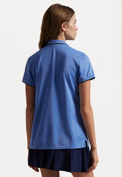 Gaišzils polo krekls ar īsām piedurknēm, kontrastējošu tumši zilu apkakli un piedurknēm, pielāgota piegriezuma un sānu spraugām, lai nodrošinātu brīvību kustībās.