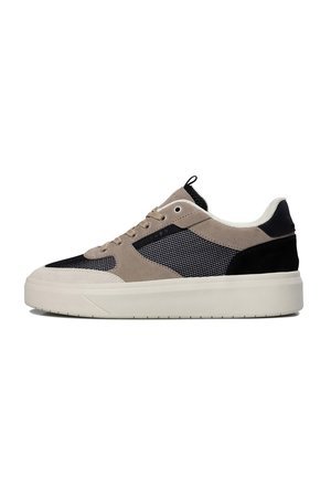 Low-top sneaker met beige suède, zwarte meshpanelen, witte zool en zwarte hieldetail, zijaanzicht op witte achtergrond.