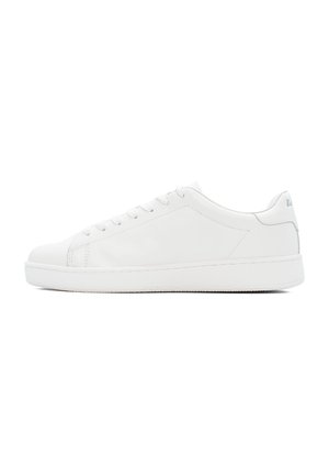 Le sneaker bianche in pelle presentano una texture liscia, punte rotonde e un design a profilo basso. Sei asole con lacci piatti e un piccolo dettaglio del logo sul tallone.