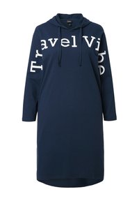 Granatowa sukienka z kapturem wykonana z miękkiego materiału, z białym napisem „Travel Vibe” na przodzie i rękawie, o luźnej, długiej sylwetce.