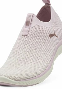 Baskets slip-on rose clair en tissu maillé texturé, avec un col rembourré et des accents rose plus foncé contrastants. Présente un logo Puma sur le côté.
