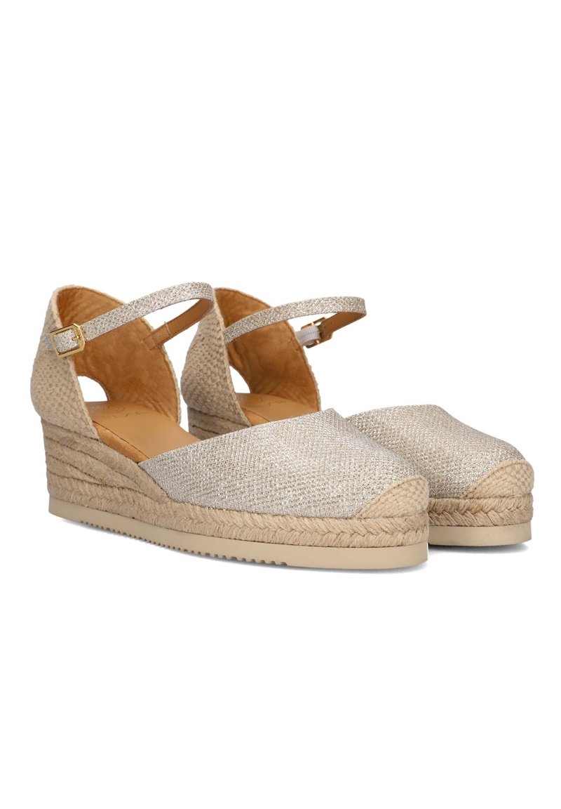 Wedge espadrilles in metallic gouden stof met een geweven jute zool. Heeft enkelbandjes en een rond teendesign.