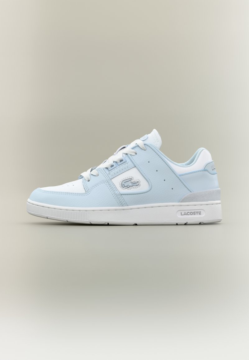 Chaussure de sport bleu clair avec des panneaux en cuir blanc, des perforations et des accents gris. Dispose de lacets blancs et d'une semelle en caoutchouc. Logo Lacoste présent.