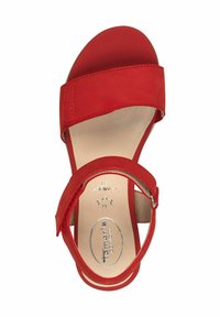 Sandal in pelle rossa con una larga fascia sopra le dita e una fascia regolabile alla caviglia. La soletta morbida presenta un dettaglio con il logo e una suola arrotondata.