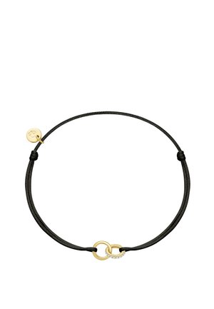 Bracelet en cordon noir ajustable avec deux anneaux dorés entrelacés, l'un décoré de petites pierres claires et un petit pendentif doré attaché.