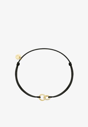 Pulsera de cordón negro ajustable con dos anillos dorados entrelazados, uno decorado con pequeñas piedras transparentes y un pequeño charm dorado adjunto.