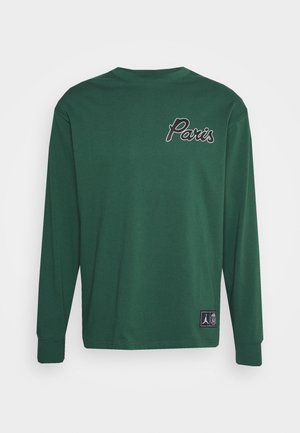 Ciemnozielona koszula z długim rękawem z napisem „Paris” na górnej lewej piersi oraz małą czarną naszywką z logo blisko dolnego brzegu.