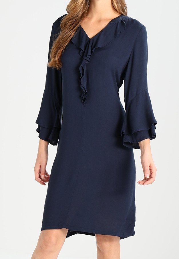 Robe bleu marine avec encolure à volants et manches évasées. Tissu léger avec une texture lisse, coupe au genou et coupe décontractée.