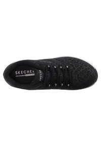 Black athletic shoe with a textured leopard pattern, lace-up design, and "SKECHERS Air-Cooled Memory Foam" branding on the tongue.