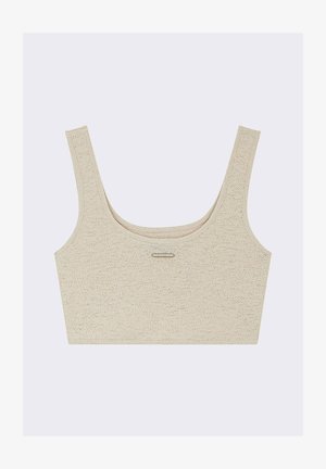 Bralette beige corto con spalline larghe, texture a costine e scollatura a barchetta. Presenta un sottile dettaglio metallico al centro davanti.