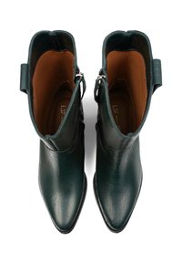 Zielone skórzane botki za kostkę z teksturą krokodyla, w szpic, z gładkim brązowym wnętrzem, wyposażone w boczne zamki błyskawiczne i krótkie pętle do szarpania.