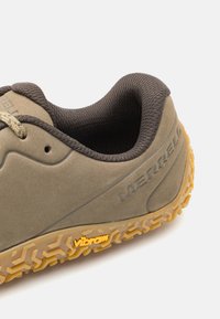 Buty Merrell z matową oliwkową cholewką, teksturowanym ciemnobrązowym kołnierzem i wytrzymałą podeszwą Vibram z żółtymi akcentami.