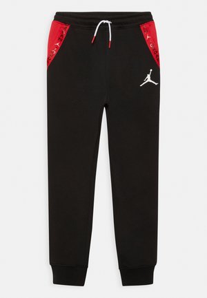 Zwarte sportieve joggers met rode zijpanelen, een wit trekkoord en een wit Jumpman-logo op de linker dij. Zachte stof met elastische boorden.