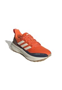 Scarpe da ginnastica arancioni con una parte superiore testurizzata, strisce bianche, suola blu navy e etichetta impermeabile. Presentano un colletto imbottito e lacci.