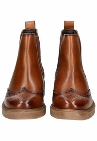 Braune Leder-Chelsea-Stiefel mit Broguerie-Details, glatter Textur, Zugschlaufe und Gummisohle, von hinten betrachtet.