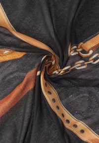 Foulard nero trasparente con accenti arancioni e beige, caratterizzato da un motivo a catena e un bordo a pois, realizzato in un tessuto morbido e texturizzato.