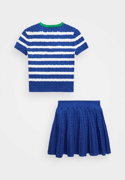 Haut en tricot rayé bleu et blanc avec des manches courtes et un col vert, associé à une jupe plissée bleue assortie en tricot texturé.