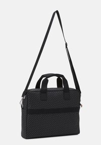 Black structured bag with textured surface, dual top handles, and an adjustable shoulder strap. Features a zip closure and logo accents.