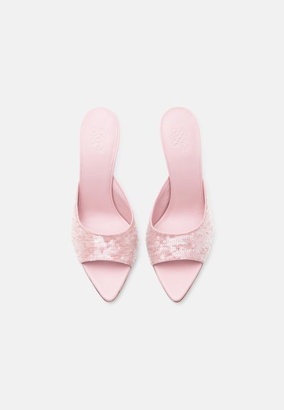 Ζευγάρι ροζ γόβες με μυτερή μύτη και φαρδιές ραμμένες με παγιέτες λουρίδες, σε λευκό φόντο, φωτογραφημένες από πάνω.