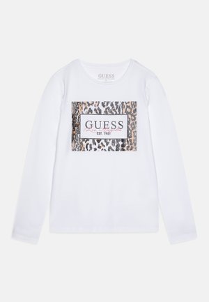 Chemise blanche à manches longues avec un rectangle imprimé léopard et le texte "GUESS Los Angeles EST. 1981" au centre devant.