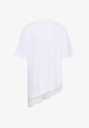 Camicia bianca a maniche corte con orlo asimmetrico e bordo in pizzo sul fondo, vista da dietro.