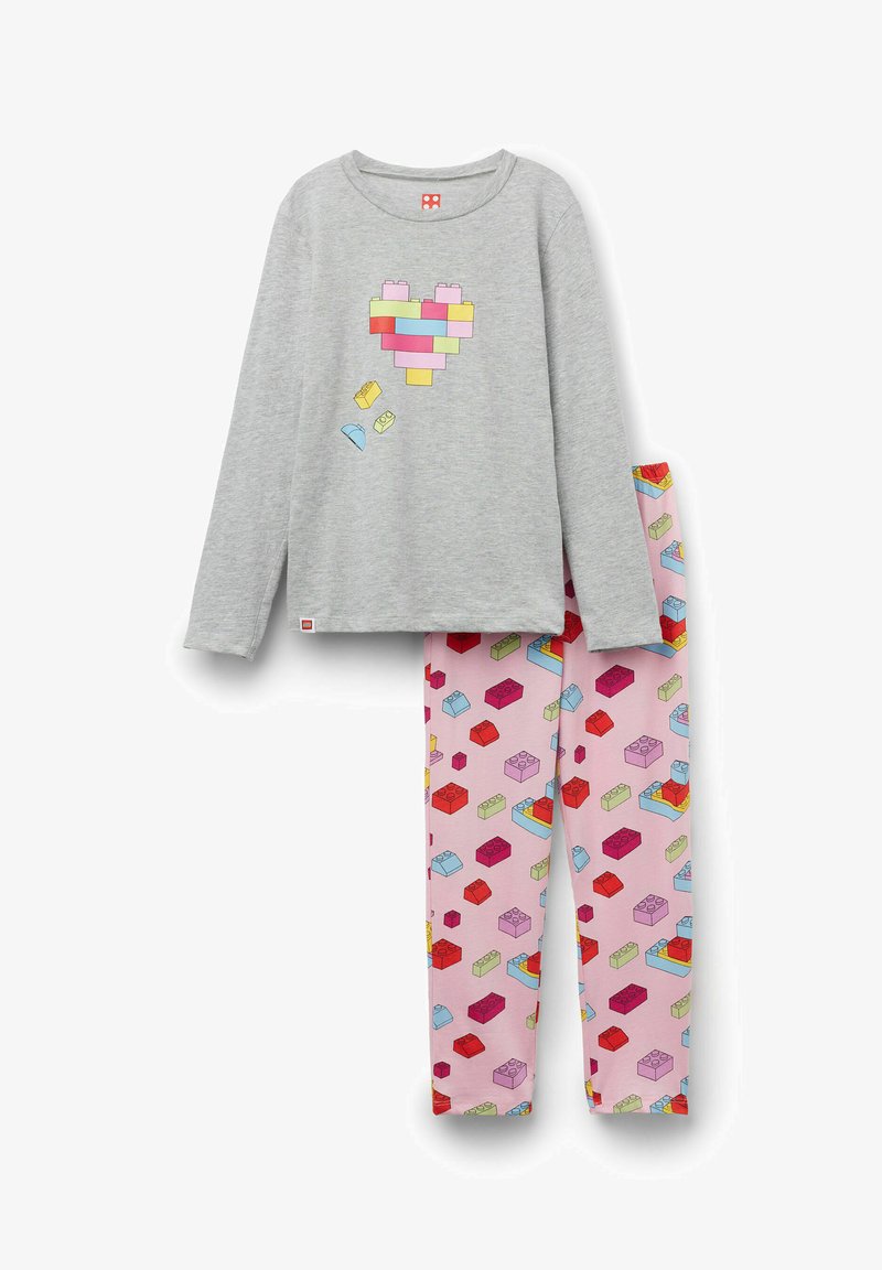 Chemise grise à manches longues avec un patch en forme de cœur fait de blocs de construction colorés et pantalon rose recouvert de motifs multicolores de blocs de construction.