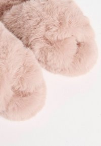 Rosa fuskpälsinnetto med en mjuk, fluffig textur, rund form och lätt glans, som framhäver tjockt, plyschigt material och böjda detaljer.