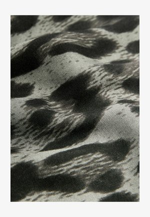 Tissu noir et gris présentant un motif abstrait et ondulé. La texture semble lisse avec un léger éclat.