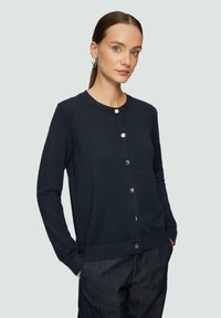 Marineblauer Cardigan mit rundem Halsausschnitt, Knopfleiste auf der Vorderseite, gerippten Bündchen und Saum. Das Material wirkt weich mit einer glatten Textur.