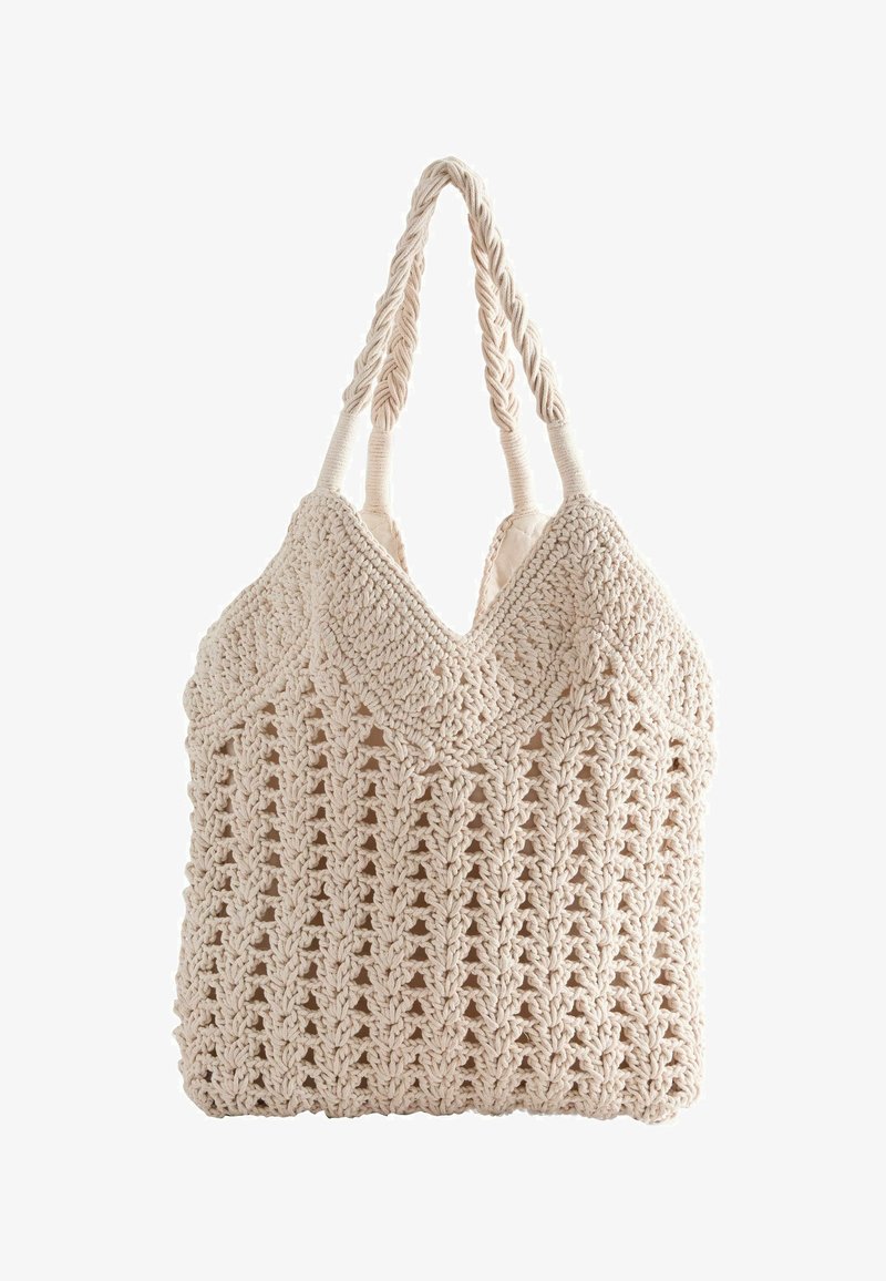 Sac fourre-tout macramé de couleur crème avec poignées tressées et motif ajouré complexe, doublure en tissu doux visible à l'intérieur.