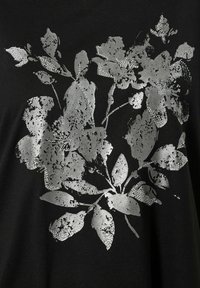 Zwarte stoffen t-shirt met een zilveren bloemenontwerp met textuuraccenten en een verouderd patroon. Het ontwerp bevat bladeren en bloemen.