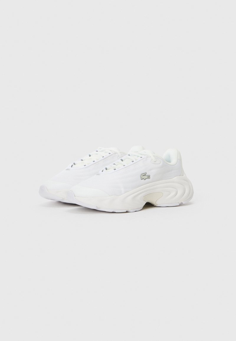 Zapatos deportivos blancos hechos de malla y materiales sintéticos, con una suela gruesa y esculpida y un diseño superior minimalista. Incluye un detalle de logo.