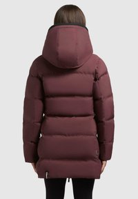 Giacca a vento bordeaux con cappuccio, design trapuntato e taglio leggermente allungato. Texture liscia con finitura traspirante e tasche laterali.