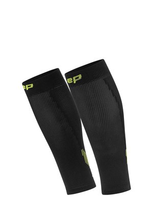 Black compression leg sleeves with ribbed texture, bright green logo detail at the top, and a fitted design providing support and moisture-wicking.