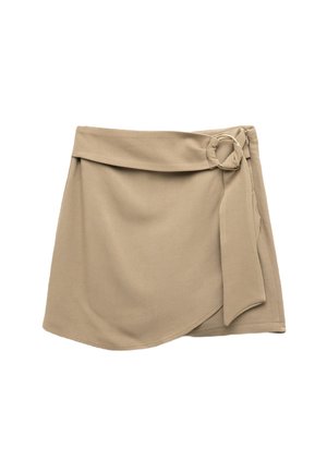 Wikkelrok in lichtbeige stof, met een zijstrik, cirkelvormige metalen hardware-accent en een gladde textuur met een vloeiende silhouet.