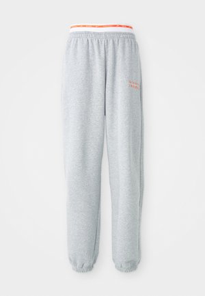 Grijze sweats met elastische tailleband met een rood en wit Nike-logo. Boorden bij de enkels, zachte stof en een relaxed fit.