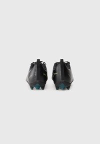 Scarpe da calcio nere con una tomaia testurizzata, dotate di un accento verde e una suola con una sfumatura blu. Design minimalista con linguette posteriori.