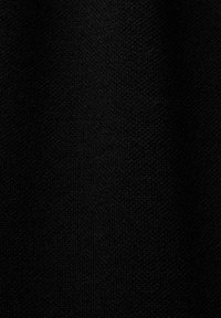 Texture de tissu tricoté noir avec des points serrés visibles et un éclairage subtil mettant en valeur le motif du tissage.