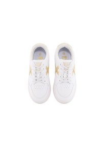 Zapatillas atléticas blancas con un exterior de cuero liso, acentos dorados, puntera perforada y cordones planos. Cuello acolchado para mayor comodidad.
