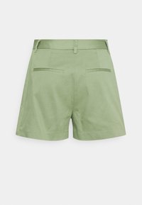 Pantaloni corti verdi realizzati in un tessuto leggero, con un design su misura, due tasche posteriori e una vita con passanti per la cintura.
