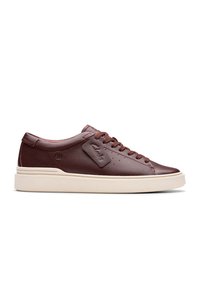Sneaker in pelle bordeaux con una finitura liscia, punta tonda, suola piatta color crema e lacci tonali. Presenta un piccolo tag con il marchio sul lato.