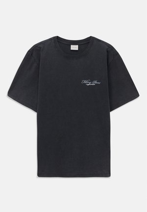 T-shirt noir à manches courtes et col rond avec un petit logo « Filling Pieces » en blanc sur la poitrine gauche.